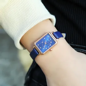 Close-up of a ladies rectangular rose gold watch with blue starry dial and leather strap