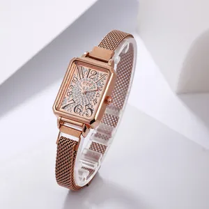 Detailed close-up of rose gold square watch dial featuring crystals and mesh strap