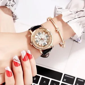 Detail of elegant rhinestone watch and star bangle on wrist with laptop background