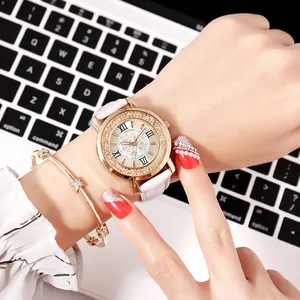 Detail of a white leather quartz watch with rose gold case and matching star bracelet