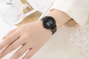 Dettaglio dell'orologio nero con cinturino a maglia e caratteri cinesi sul quadrante