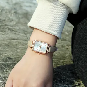 Close-up of a vintage square watch with rose gold case and rhinestones on a wrist