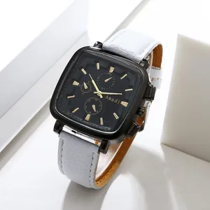 Close-up of Amadi square black watch face with gold markers and white leather strap