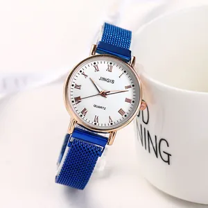 Détail d'une montre à quartz or rose avec bracelet milanais bleu et chiffres romains