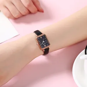 Retro rectangular watch with rose gold case and black leather strap worn on wrist