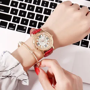 Close-up of a red leather watch with rhinestones and a matching gold star bracelet