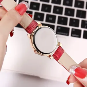 Close-up of rose gold watch case back and red crocodile texture leather strap