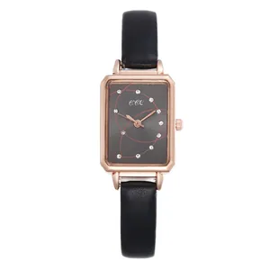Close-up of square rose gold watch case with dark dial and black leather texture strap