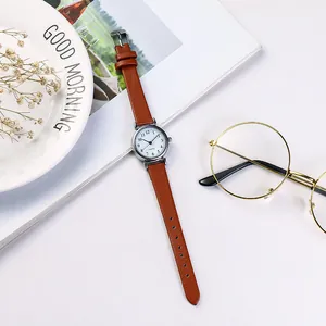 Classic small dial quartz watch with brown leather strap displayed with morning lifestyle props