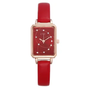 Detail of red leather strap and rectangular rose gold quartz watch for women