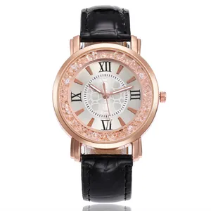 Detail of rose gold watch with moving rhinestones, Roman numerals and black leather band