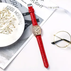 Détail de montre en cuir rouge avec boîtier tonneau en cristaux et chiffres