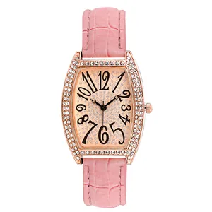 Détail d'une montre tonneau or rose avec lunette en strass et bracelet cuir crocodile rose