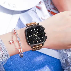 Close-up of square black watch dial with gold markers and matching star charm bracelet