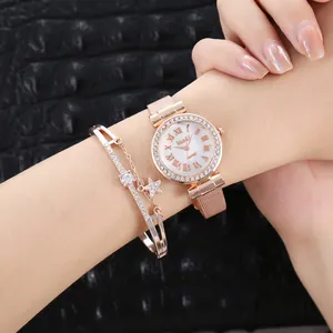 Dettaglio dell'orologio in maglia oro rosa e set di bracciali a stella con strass neri