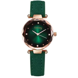 Detail of rose gold quartz watch featuring forest green dial and faceted crystal glass