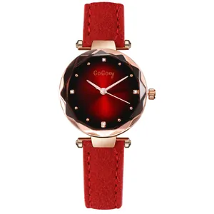 Close-up of diamond-cut glass mirror and gradient red dial on a fashion leather watch