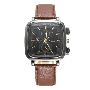 Detail of square silver metal watch case with black dial and brown leather strap