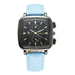 Close-up of square black watch dial with gold markers and light blue leather strap