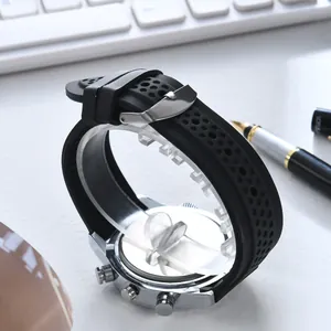 Men's sports watch with silver steel case and black perforated silicone strap on desk
