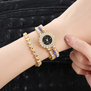 Detalle de reloj dorado para mujer con esfera estrellada y pulsera de corazones joya