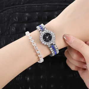 Detalle de reloj de cuarzo plateado con pedrería azul y pulsera con forma de corazón