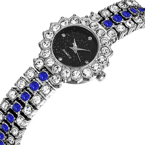 Detalle del bisel de flor plateada del reloj con cristales azules y blancos