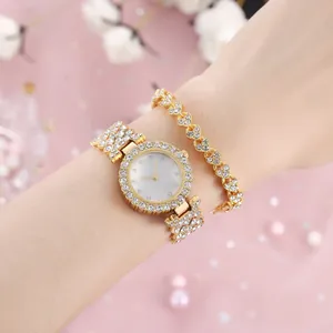 Dettaglio dell'orologio in strass dorati e braccialetto a cuore su sfondo rosa