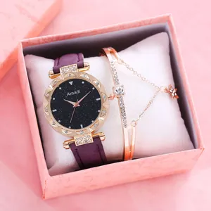 Detalle de reloj cielo estrellado con correa púrpura y pulsera dorada a juego en caja