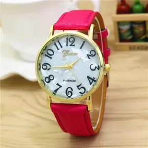 Close-up of pink leather watch band and white mother of pearl dial on wood table