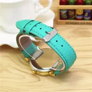 Detail view of the mint green leather strap and golden case of the stylish quartz watch