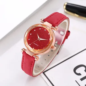Detail of red glitter watch face and rose gold casing with frosted leather strap