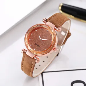 Close-up of rose gold quartz watch with brown starry dial and rhinestone markers