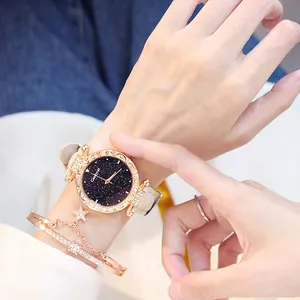 Detail of star dial watch with leather strap and rose gold bracelets on female wrist