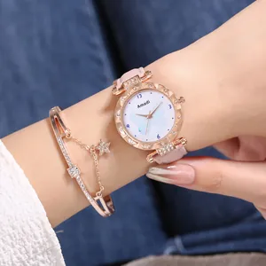 Détail d'une montre à quartz or rose avec bracelet en cuir rose et bracelet étoile assorti