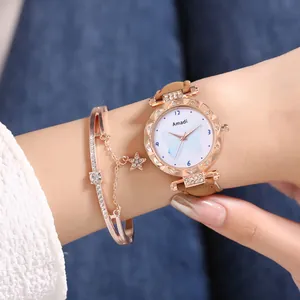Détail d'une montre femme en or rose et bracelet à étoile porté au poignet féminin