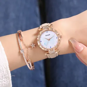 Détail d'une montre à quartz or rose avec bracelet cuir blanc et bracelet étoile