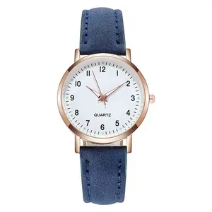 Detail of rose gold quartz watch with white numeric dial and blue suede leather strap