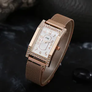 Detail of rose gold rectangular quartz watch with rhinestone bezel and milanese mesh band