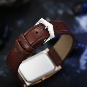 Close-up of brown leather watch strap with silver buckle and rectangular case back