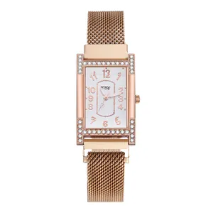 Detailed macro of rose gold Milanese strap and H-shaped rhinestone bezel on quartz watch