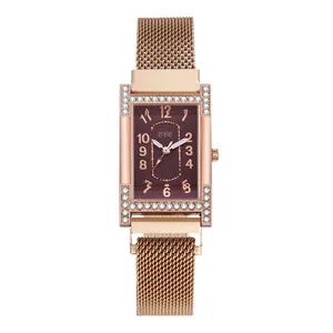 Detail of rose gold rectangular watch with crystal bezel and brown sunray dial texture