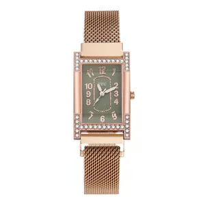 Close-up of rose gold mesh strap watch with rectangular rhinestone case and green dial