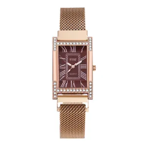 Detail of H-shaped rose gold watch case with crystal accents and brown sunburst dial
