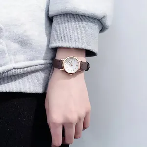 Elegant women's quartz watch with rose gold case and brown leather strap on wrist
