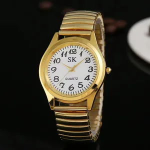 Détail macro d'une montre à quartz dorée avec bracelet extensible sur grains de café