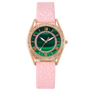 Detail of rose gold watch with green malachite dial and pink ostrich texture leather strap