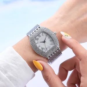 Montre femme forme tonneau argentée avec lunette en strass et cadran romain au poignet