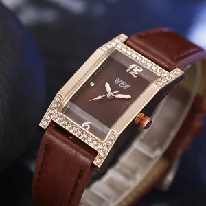 Macro shot of rectangular rose gold watch with crystal inlay and brown leather strap