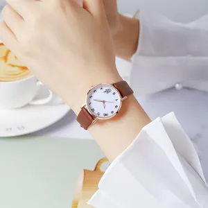 Montre tendance pour femme avec bracelet en cuir marron et boîtier en or rose au poignet